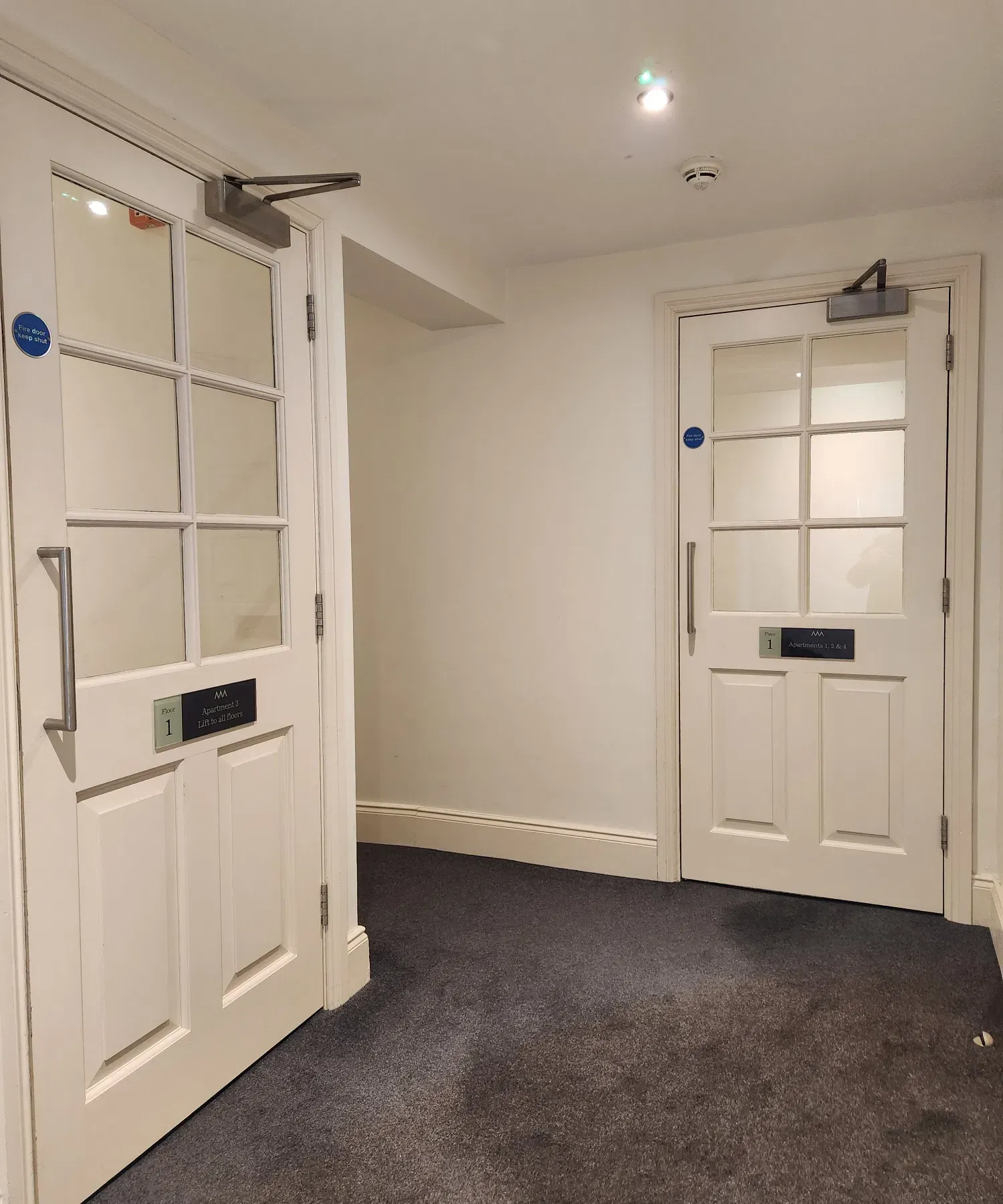 White glass-panelled fire doors in a managed residential building